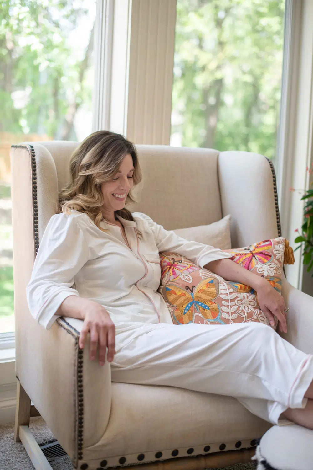 A woman wearing Just Because Love Does healing bamboo pajamas lounging in a chair