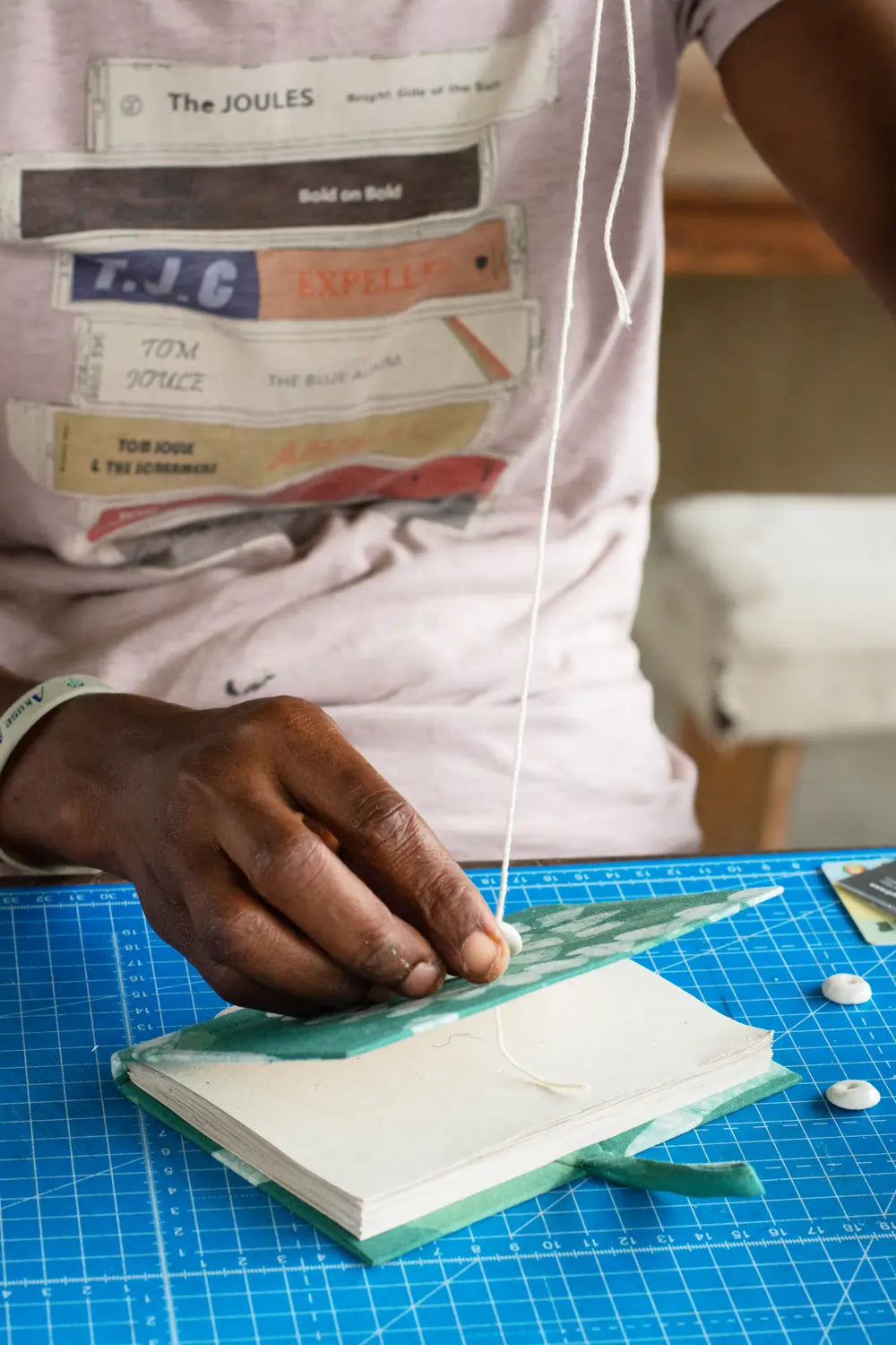 a craftsperson sewing beads onto journals for Just Because Love Does